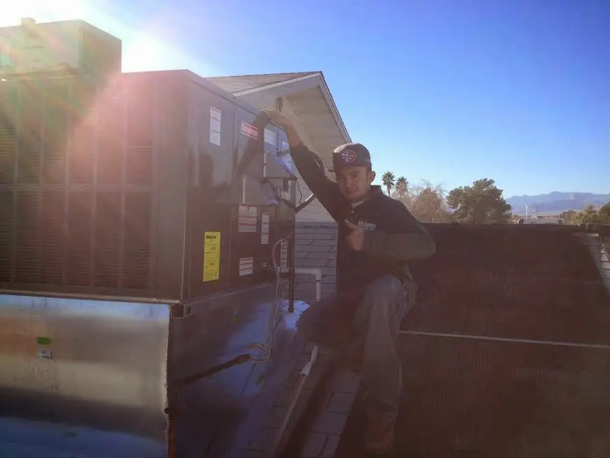HVAC technician performing Heat Pump Repair on a rooftop unit in Golden